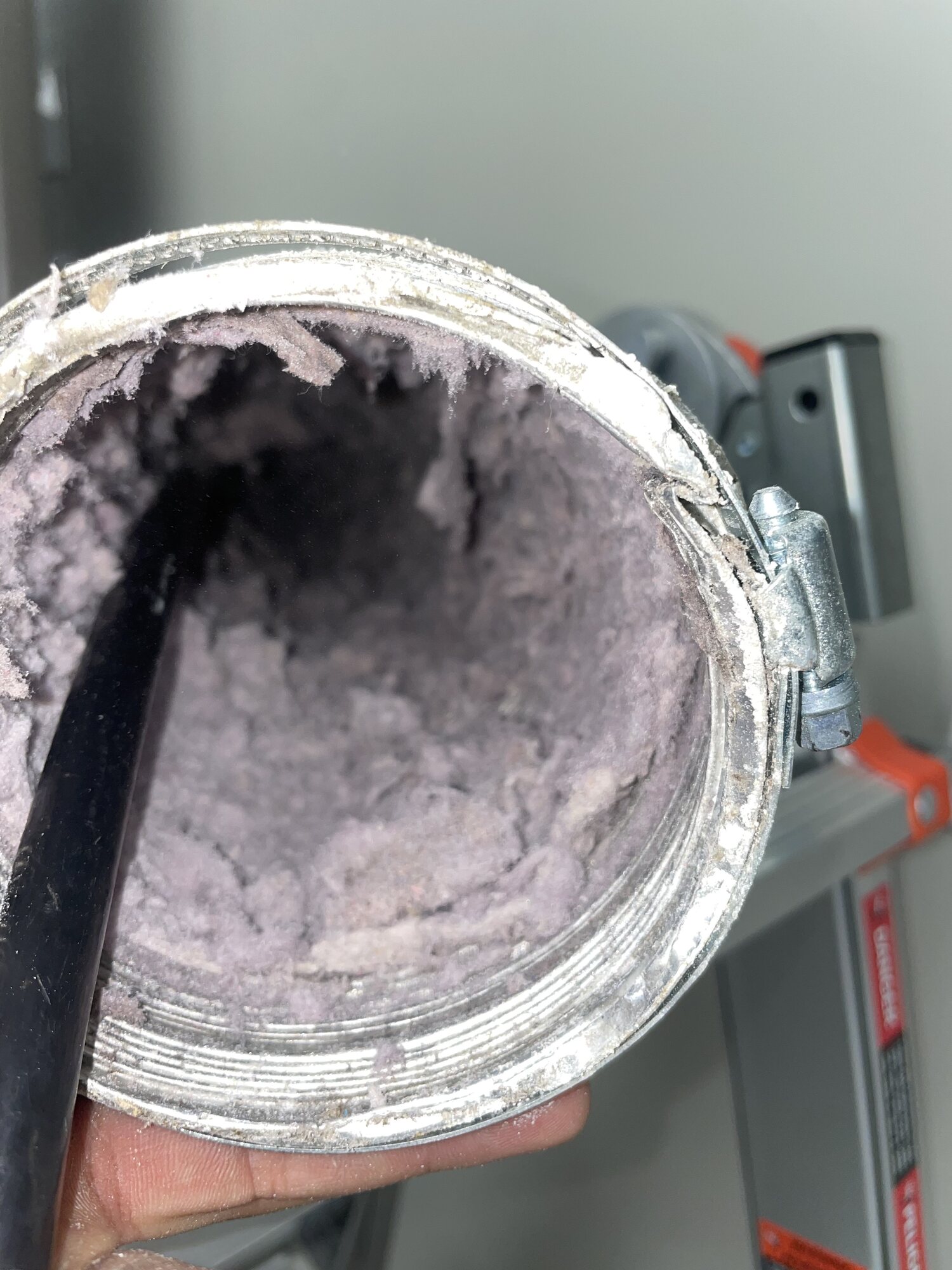 Close-up of lint buildup visible inside a dryer vent connection.