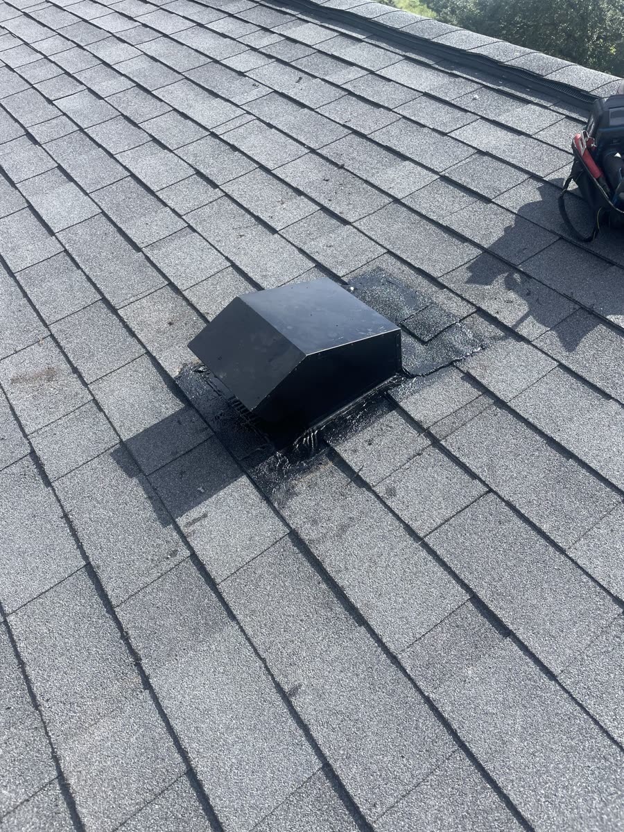 Second angle of the same completed rooftop dryer vent, showing the installed vent cap and sealed flashing